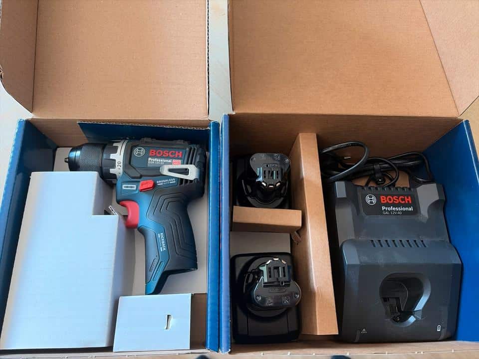 Bosch GSR 12V-32 im Karton neben zwei Akkus und einem Ladegerät